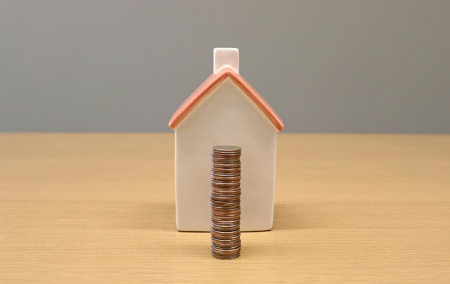 coins stacked infront of house for cashflow management scaled